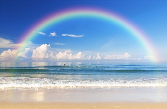 rainbow over the ocean on a beach